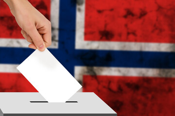 hand drops the ballot election against the background of the flag, concept of state elections,...