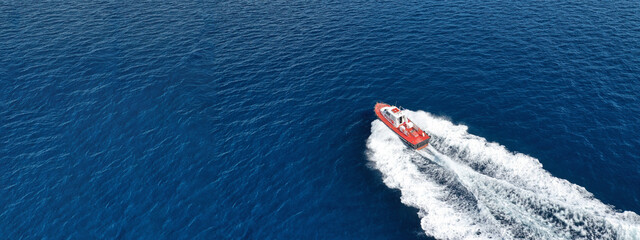 Aerial drone ultra wide photo of small pilot vessel cruising near mediterranean port with deep blue...
