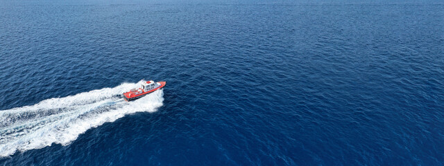 Aerial drone ultra wide photo of small pilot vessel cruising near mediterranean port with deep blue sea