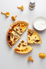 Sliced chanterelle quiche on white table