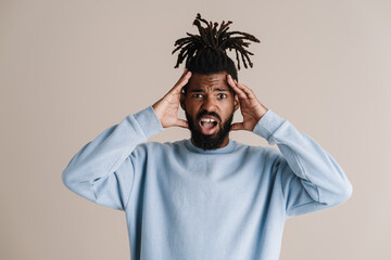 Shocked african american guy screaming and grabbing his head