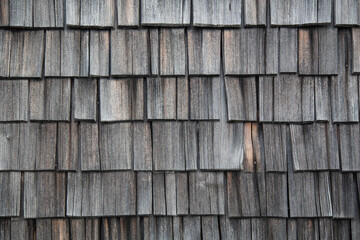 Old handcraft: Wooden and weathered shingles covering a house wall