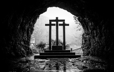 Three Christian crosses in a cave. Black and white