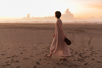Fototapeta na wymiar 海辺を歩く女性