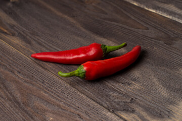 Two fresh chili peppers on a dark wood background, copyspace