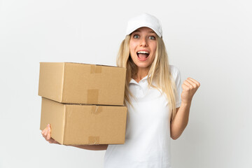 ¬°Young delivery woman isolated on white background celebrating a victory in winner position