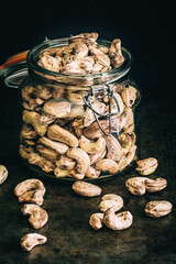Raw unpeeled cashew nuts on a dark background