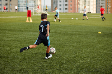 young caucasian footballers on football match in stadium, soccer players running, exercising, on competition