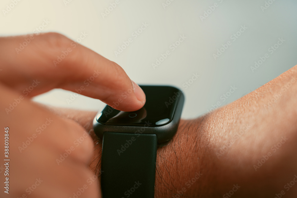 Poster Man using trendy smart watches mobile app on touch screen.New gadget to view incoming messages and calls to a mobile phone.Stylish touchscreen wrist watches with navigation mobile application