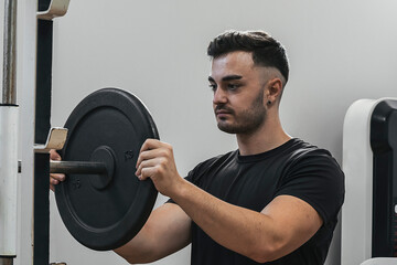 Fototapeta na wymiar boy preparing weights to lift