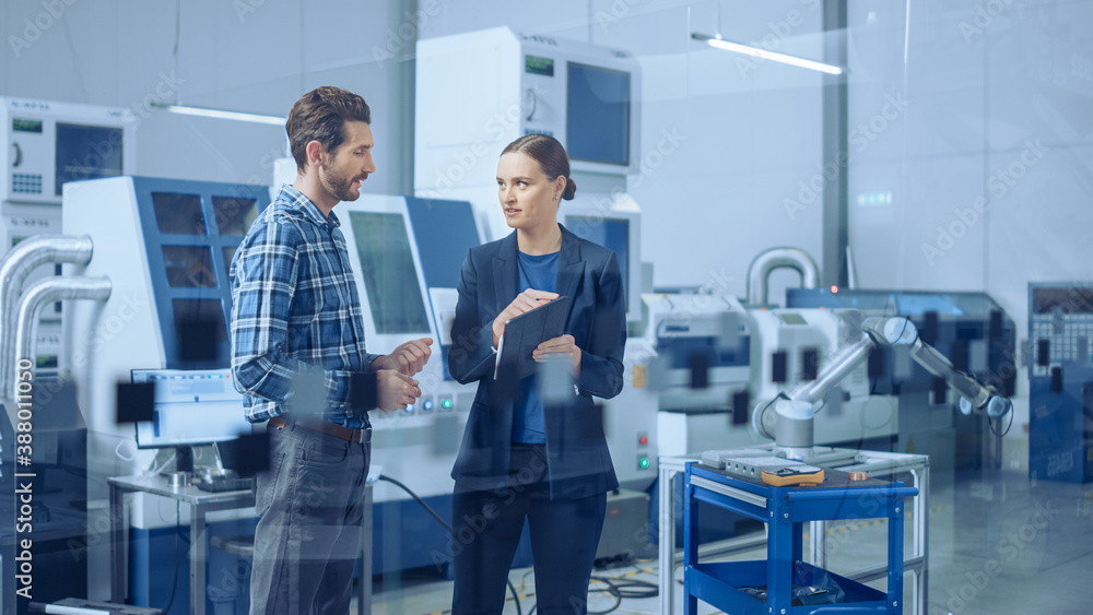 Poster Modern Factory: Female Project Manager and Male Engineer Standing, Talking, Using Digital Tablet for Programming and Monitoring Assembly Line with Robot Arm. Industry 4.0 Facility with CNC Machinery