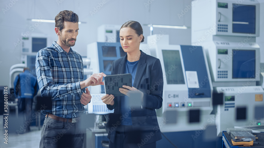 Poster modern factory: female project manager, male engineer standing, talking, using digital tablet for pr
