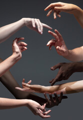 Common goal. Hands of different people in touch isolated on grey studio background. Concept of...