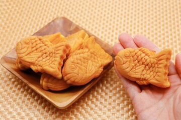 木製の皿に盛られたたい焼き　手に持ったたい焼き