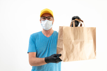 Delivery guy with protective mask holding paper bag with groceries.