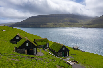 Cottages near B&ouml;ur village, V&aacute;gar, Faroe Islands. The cottages are built with inspiration from the old traditional Faroese houses. Stone foundation, white window bars and grass on the roof.