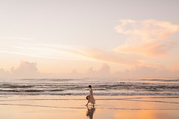 海辺を歩く女性 © One