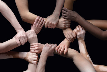 Together. Hands of different people in touch isolated on black studio background. Concept of...