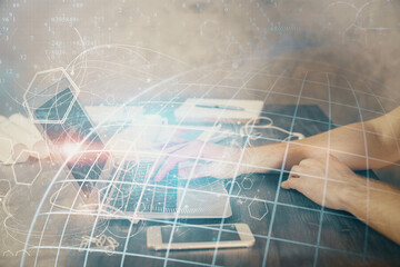Multi exposure of world map hologram with man working on computer on background. Concept of worldwideweb.