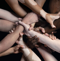Support. Hands of different people in touch isolated on black studio background. Concept of...