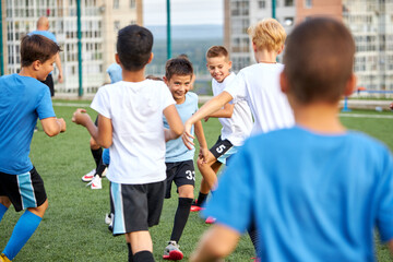 young caucasian footballers on football match in stadium, soccer players running, exercising, on competition