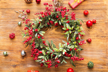 Beautiful Christmas wreath and decor on wooden background