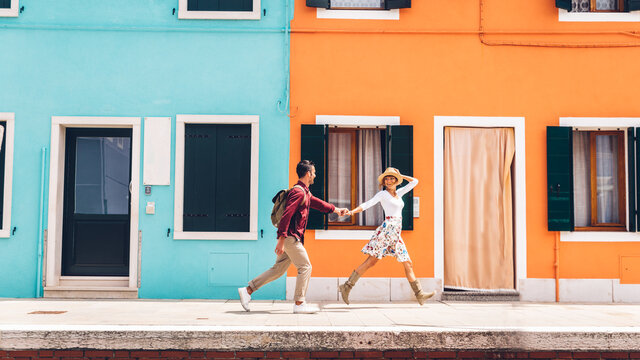 Couple of happy tourists visiting Burano, Italy - Boyfriend and girlfriend in love spending a romantic weekend in Venice, Italy.