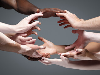 Planet Earth. Hands of different people in touch isolated on grey studio background. Concept of...