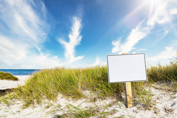 signpost with copy space on wide sandy beach against sea and blue sky © Christian Horz