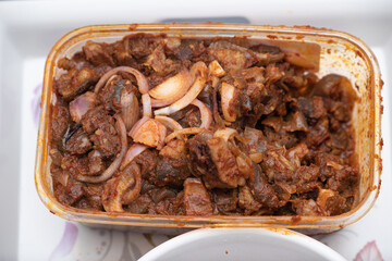 A picture of a locally prepared dish made up of spicy peppered goat known as Asun