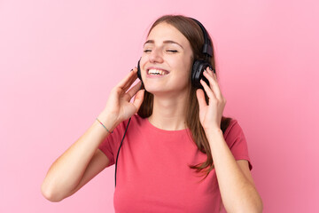 Naklejka premium Young woman over isolated pink background listening music and singing