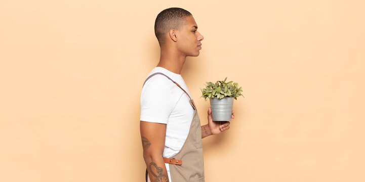 young black man on profile view looking to copy space ahead, thinking, imagining or daydreaming