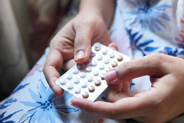 women hand golding birth control pills close up 