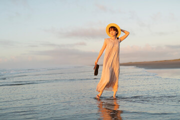 Fototapeta na wymiar 海辺を歩く女性