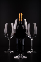 wine bottles and full glass with black background