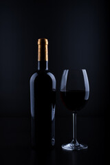 closeup wine bottle and glass with black background