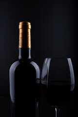 closeup wine bottle and glass with black background