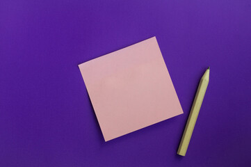  Stationery pink sticker on purple background with light wooden short small pencil