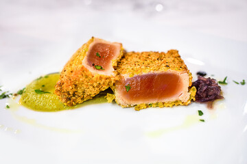 Tuna dish with pistachios crust on the plate in the restaurant
