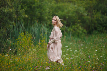 beautiful girl walking in a blooming field