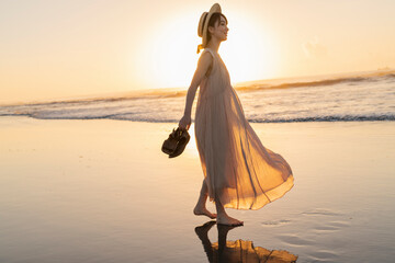 海辺を歩く女性 © One