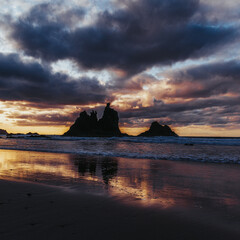 Paisaje de una playa con rocas en el atardecer