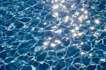 Water background with glitter under the sun