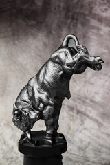 An action figure of a silver bull standing on its front legs.