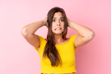 Fototapeta premium Teenager Brazilian girl over isolated pink background frustrated and takes hands on head