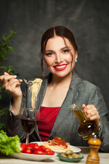 Happy young woman eating italian pasta in restaurant