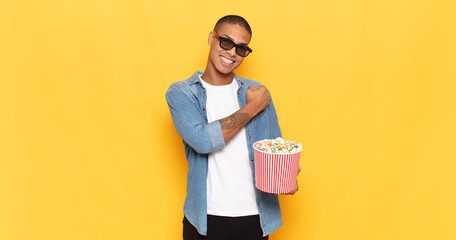 young black man feeling happy, positive and successful, motivated when facing a challenge or celebrating good results