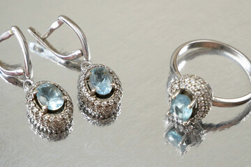 earring with big blue topaz and white diamonds around and ring jewerly shop, pawnshop concept,