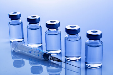 Vial with liquid drug as vaccine dose flu shot along with syringe for injection treatment on...
