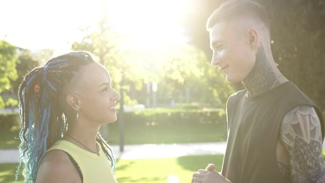Portrait of a beautiful modern romantic young couple of man and woman on the background of sunset and sun rays